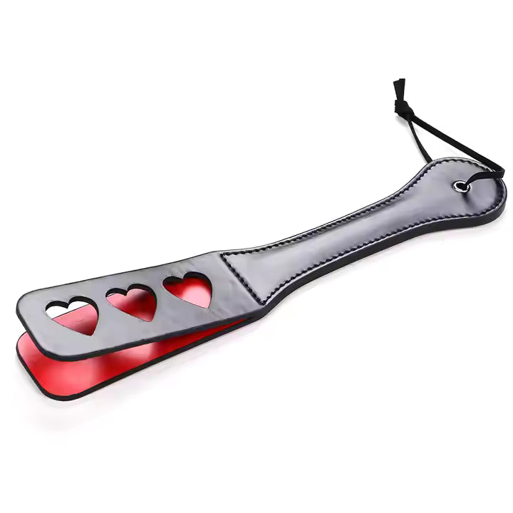 Sole punishment paddle with heart designs on a white background