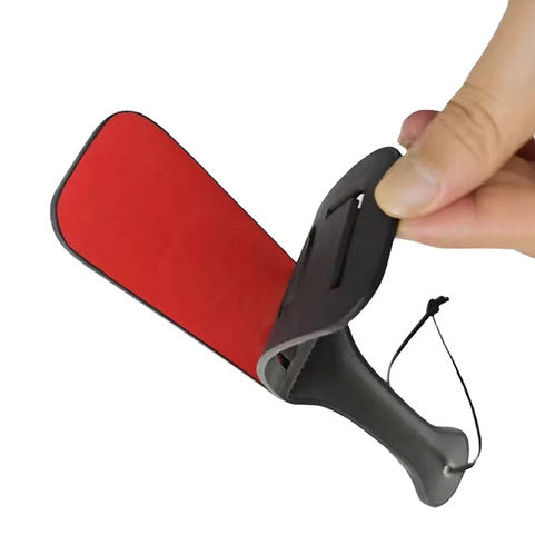 Red and black rubber cleaning pad held by a hand on a white background