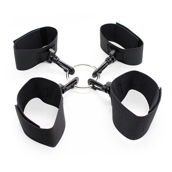 Black wrist and ankle restraints on a white background