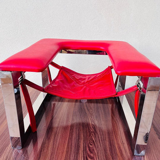 Red bench with chrome legs on a wooden floor against a white wall
