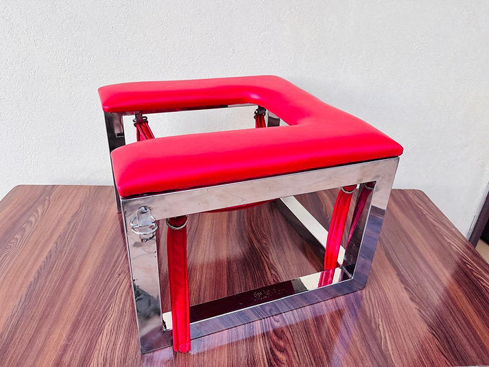 Modern chair with red seat and backrest on a wooden surface