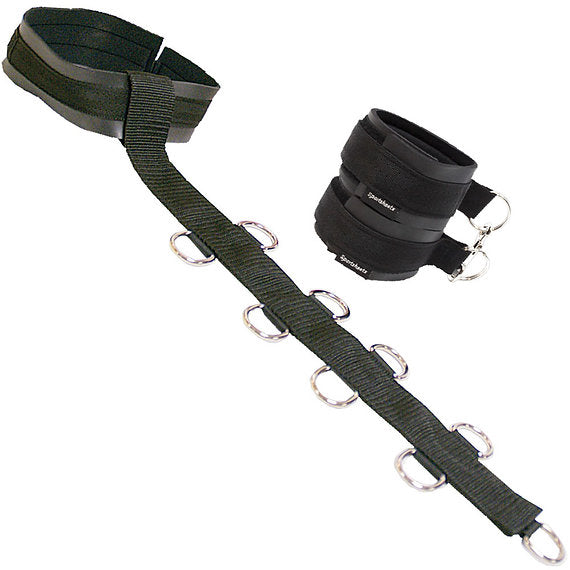 Black harness with multiple straps and metal rings on a white background
