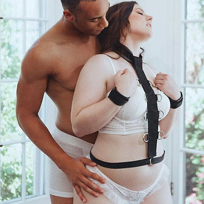 Man and woman in a romantic pose with a black harness